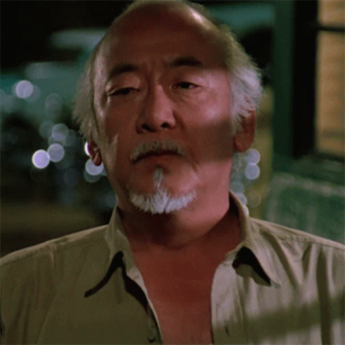Gif animado do Sr Miyagi triste e abaixando a cabeça.